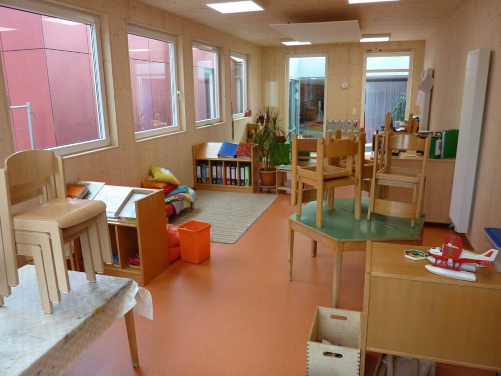 KiTa‑Gruppenraum Komplettmodul in Holzbauweise mit integrierten Heizungsinstallationen, angepasster Fassade und Glasüberdachung.