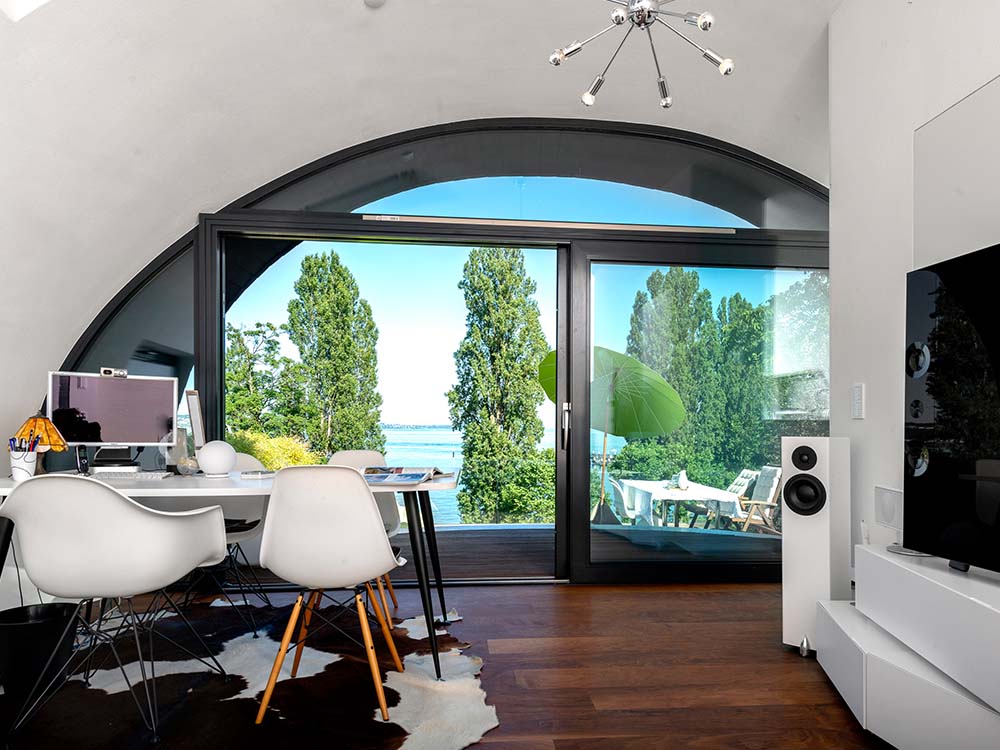 Wohn‑Ei „Parasit“ auf Flachdach am Bodensee — aufgesetzter Baukörper, nutzbare Dachfläche, Flachdach, Holzbauweise.