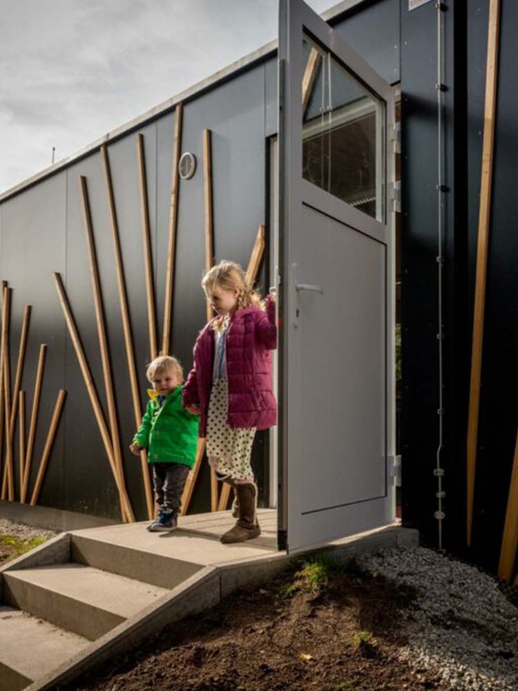 Klassenzimmer‑Modul in Holzbauweise mit integrierter Haustechnik nach Nachttransport und Aufstellung per Schwerlastkran — Klassenzimmer, Holzmodulbau, Haustechnik.