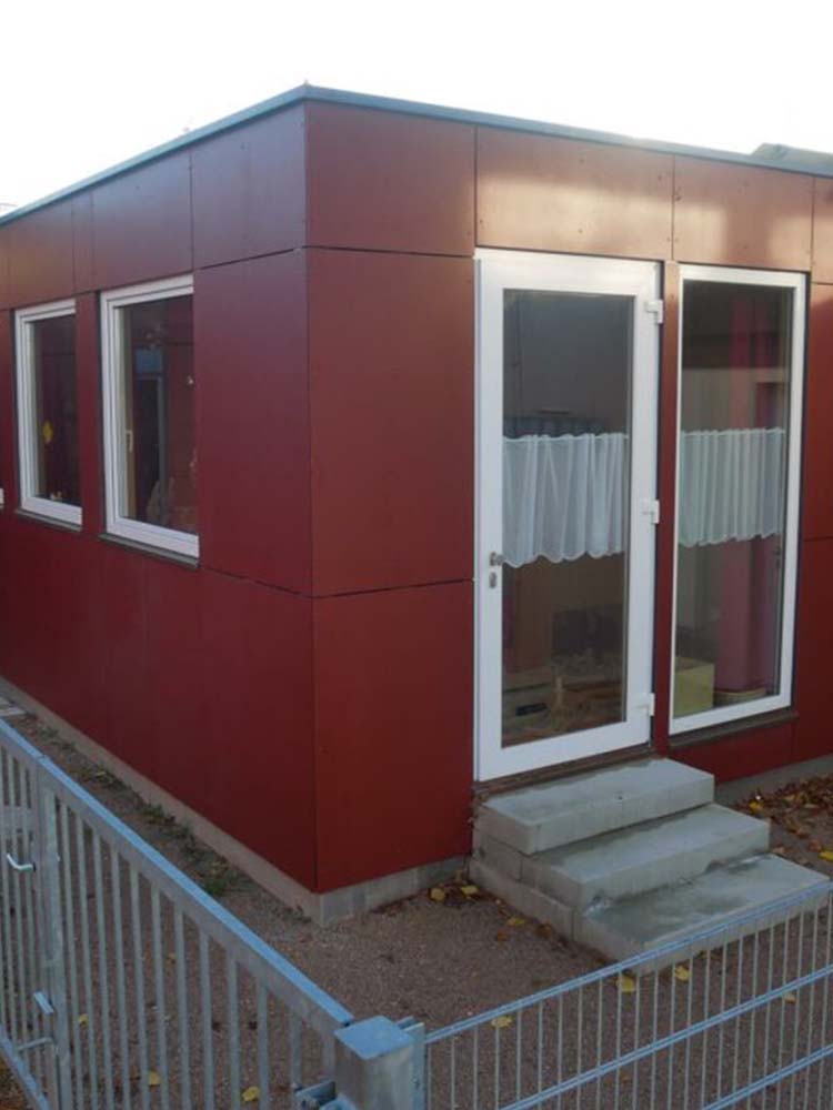 KiTa‑Gruppenraum Komplettmodul in Holzbauweise mit integrierten Heizungsinstallationen, angepasster Fassade und Glasüberdachung.