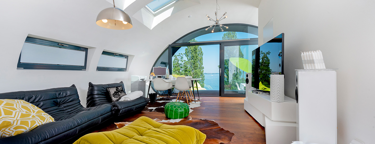 Innenansicht des Wohn-Ei Holzhauses mit hellem Holzfußboden und moderner Einrichtung – nachhaltiges Traumhaus im Neubau aus Holzbau.