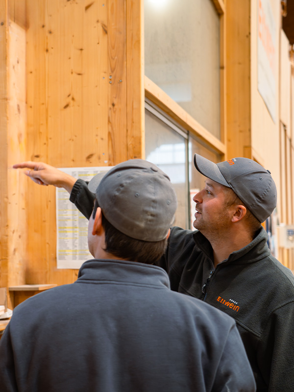 Zwei Ettwein-Mitarbeiter besprechen Maßnahmen zur Steigerung der Energieeffizienz und Dämmung eines Gebäudes.