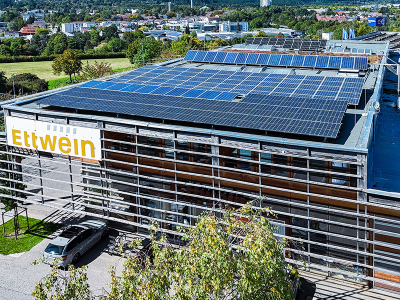 Ettwein Firmengebäude mit sichtbarer PV‑Anlage auf dem Dach als Beispiel grüner Produktion — Nachhaltigkeit, Verantwortung, Solarenergie, Klimaschutz.