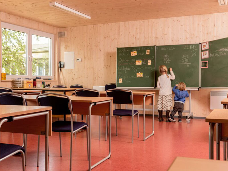 Innenaufnahme einer modernen Grundschule in Holzbauweise von Ettwein – warme Holzoptik, nachhaltiger Bau und gesundes Raumklima für Kinder.